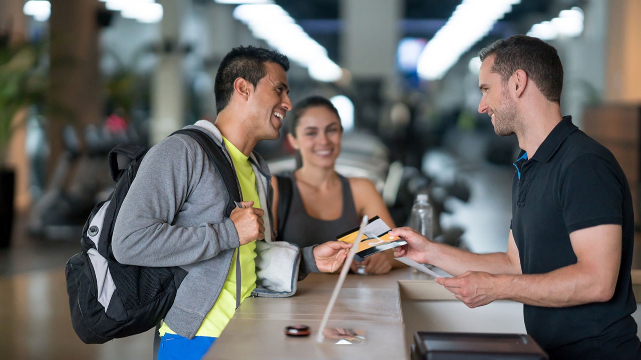 people talking at gym reception