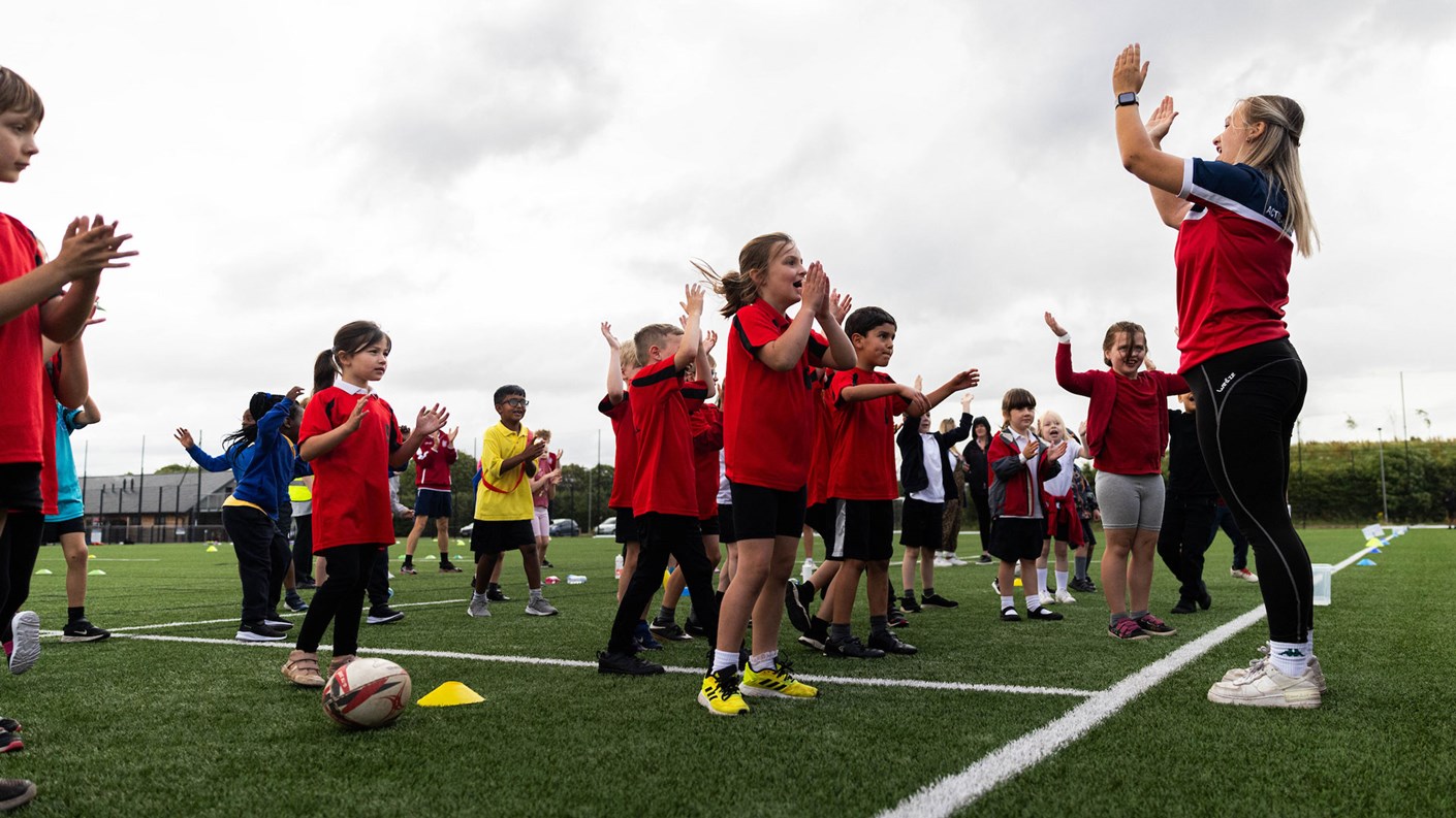 children on playing field with coach