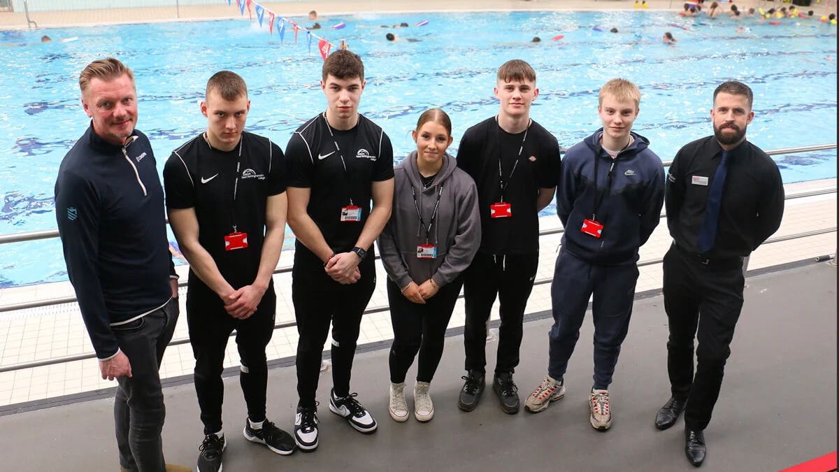 A group of West Notts students standing at a poolside alongside two members of staff