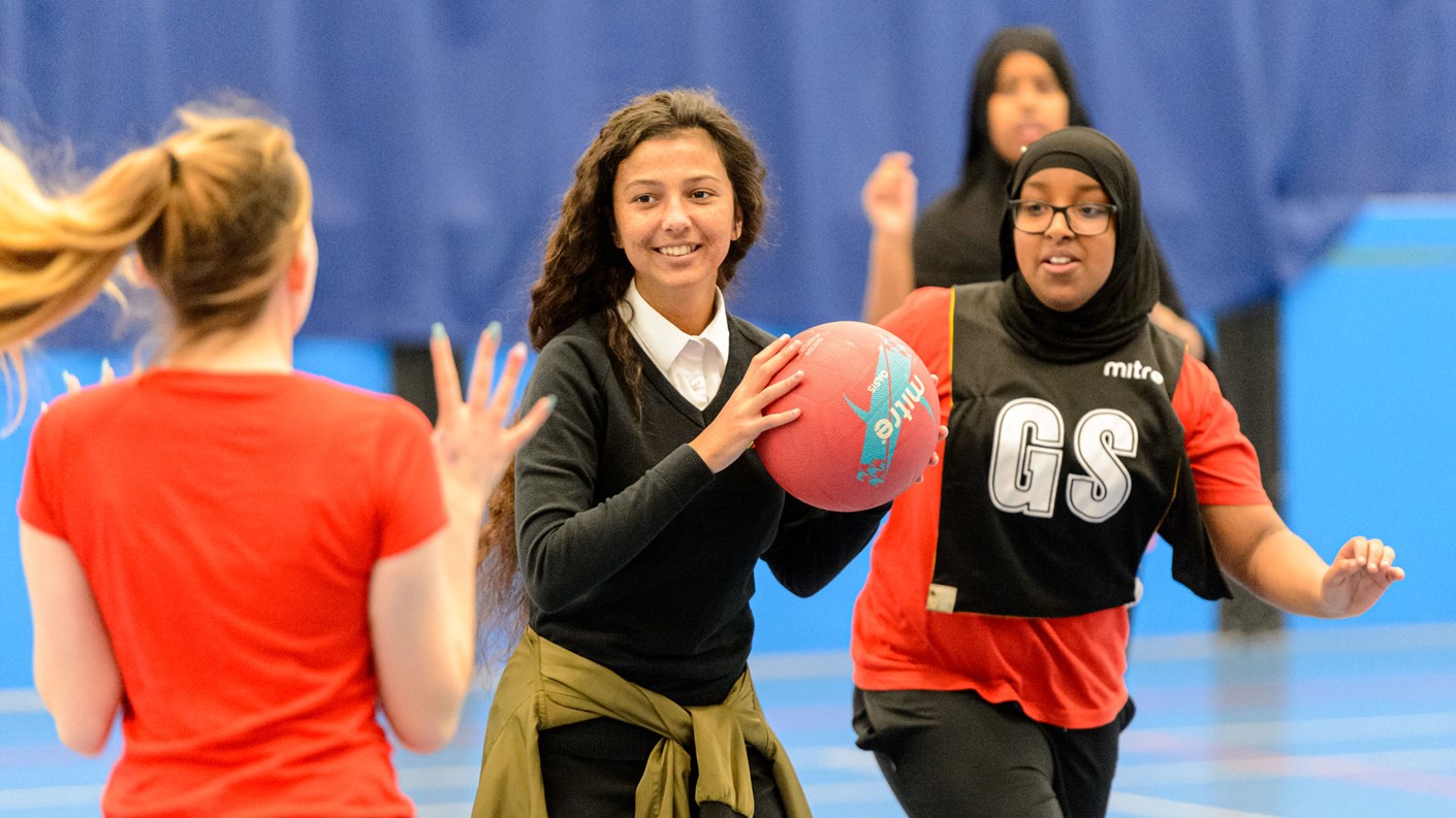three girls playing indoor netball