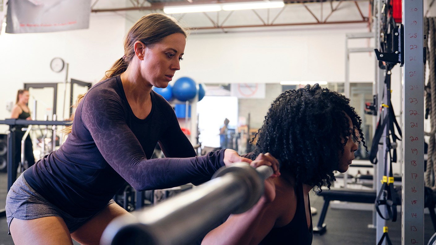 Female gym instructor or personal trainer working with a female client