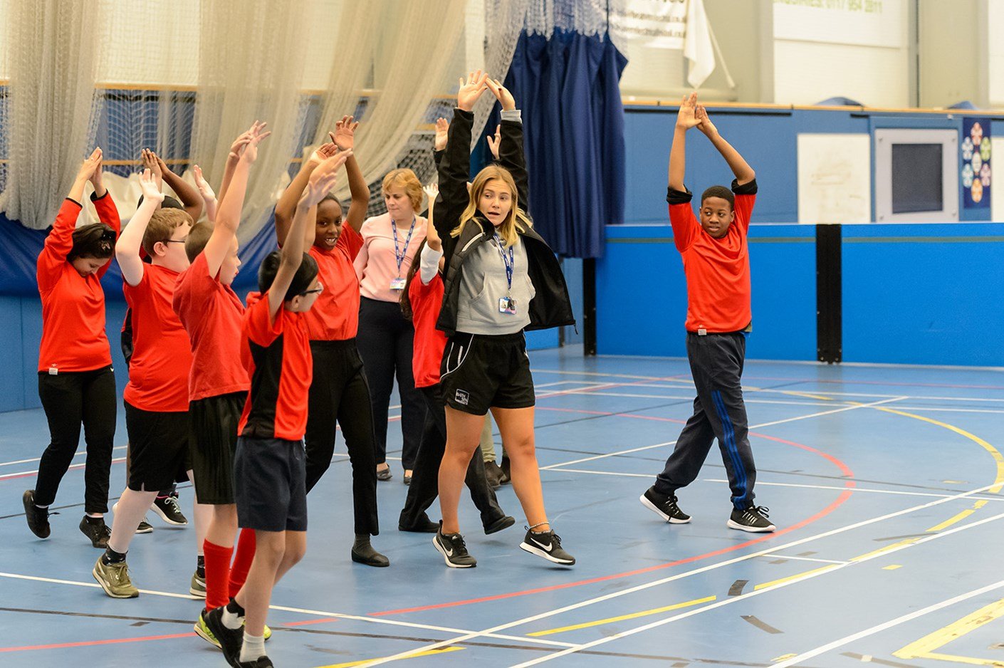 A coach stretching with a group of children