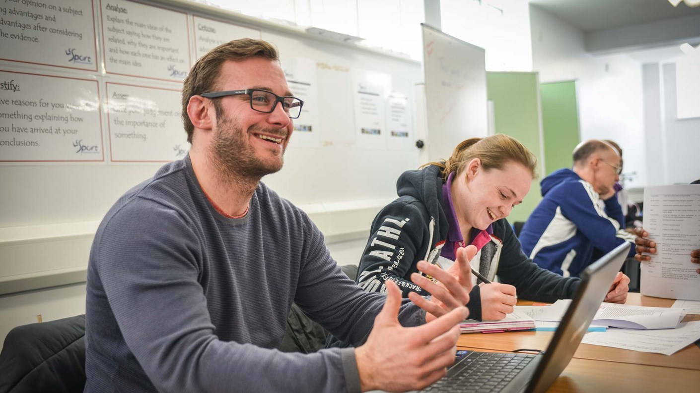 College students working at laptops in a class