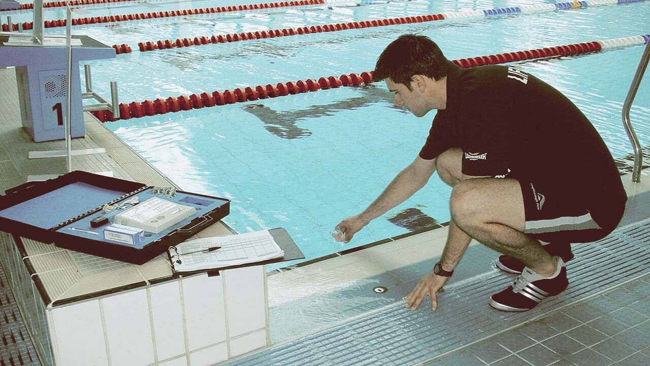 person testing pool water